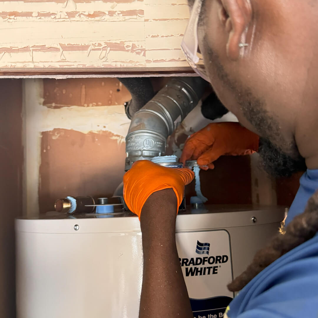 Showing the Koala Cooling and Plumbing Technician working on a water heater 
